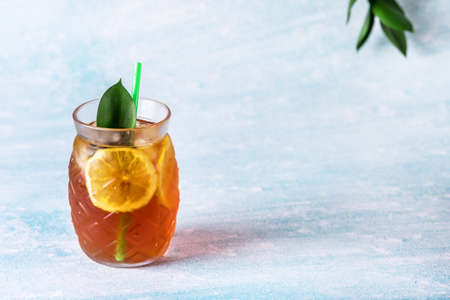 Glass of Iced Tea with Lemon Slices Blue Background Horizontal Refreshing Healthy Summer Drink Copy Spaceの写真素材