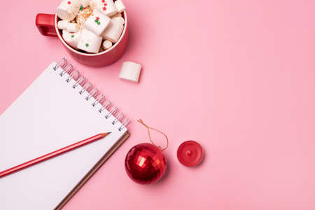 Holiday Christmas Background with Notepad Cup of Cocoa with Marshmallow and Red Pencils and Christmas Decoration Horizontal Copy Spaceの写真素材
