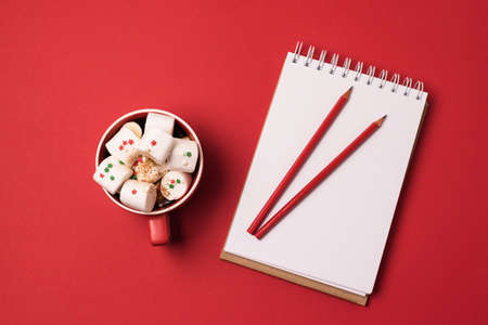Holiday Christmas Background with Notepad Cup of Cocoa with Marshmallow and Red Pencils Horizontalの写真素材