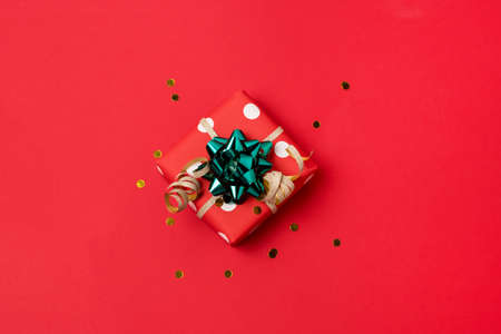 Gift Box for Christmas Holidays on Red Background Confetti Festive Background Horizontalの写真素材