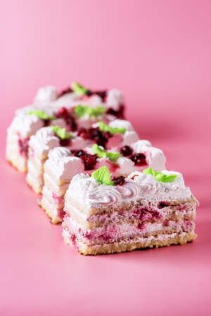 Pieces of Tasty Homemade Biscuit Cake on Pink Background Tasty Dessert with Cream Verticalの写真素材