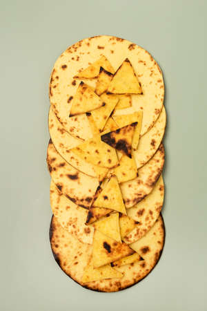 Stack of Tasty Homemade Whole Wheat Flour Tortilla and Tortilla Chips on a Green Background Top View...