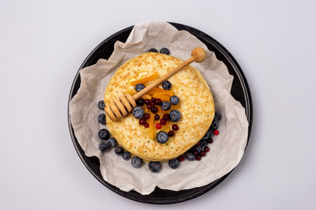 Fresh Baked French Crepes or Russians Blinis with Honey and Berry on Plate Gray Background Top Viewの写真素材