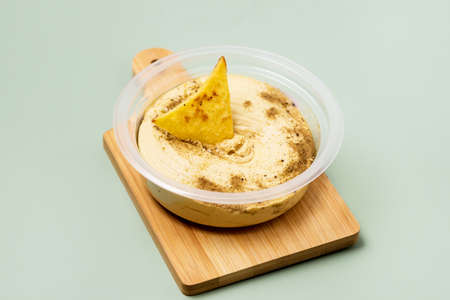 Tasty Homemade Hummus with Tortilla Chips on Green Background Healthy Diet Food Horizontalの写真素材