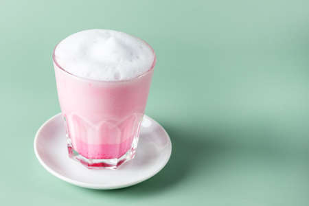 Matcha Pink Tea Latte in glass on Green Background Healthy Drink Copy Space Horizontalの写真素材