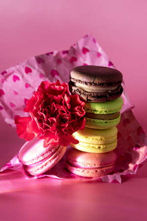 Dark Photo of Stack Delicious Homemade French Macarons on Pink Background Modern Dessert Flower Verticalの写真素材