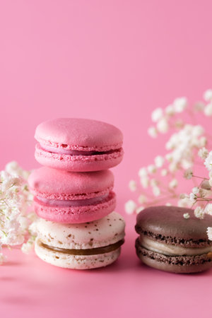 Macarons of Different Color on Pink Background Flowers Verticalの写真素材