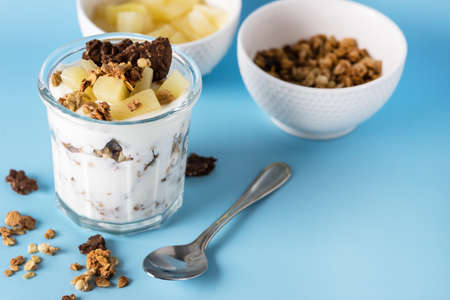 Glass of Diet Dessert with Yogurt Muesli or Granola Diet Cookies with Oatmeal and Fruit Blue Background Healthy Diet Breakfast Horizontalの写真素材