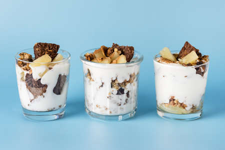 Trifle with Chocolate Cookies Oatmeal (Granola) Cream and Pineapple in a Glasses Healthy Portioned Dessert Blue Background Horizontalの写真素材