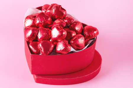 Beautiful Red Chocolate Hearts Candies in Red Box Shape of Heart on Pink Background St Valentine Day Background Dessertの写真素材