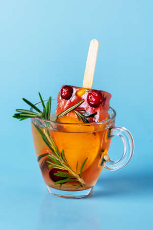 Healthy Summer Dessert Frozen Berry and Citrus Tea ice with Rosemary in Glass Tea Cup Verticalの写真素材