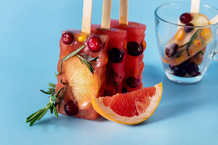 Natural Berry and Fruit Tea Flavor ice on Blue Background Summer Refreshing Delicious and Healthy Treat or Desserts ice for Tea Horizontal Glass Tea Cupの写真素材