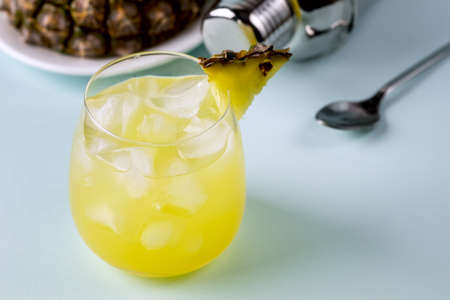 Pineapple Cocktail or Juice in Glass with Ice Cube Tasty Refreshing Drink Blue Background Horizontal