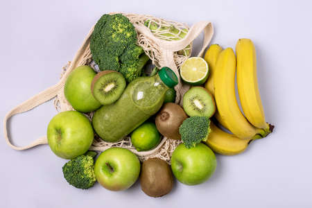 Healthy Green Smoothie in a Glass Bottle made of Banana Green Apple Kiwi Broccoli Top View Raw Vegan Food Conceptの写真素材