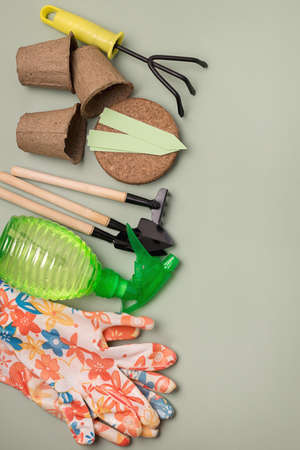 Spring Gardening Tools on Green Background Pots Gloves Coco Substrate Spade Rake Copy Space Verticalの写真素材