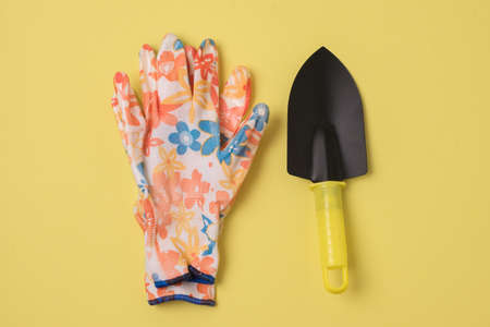 Garden Trowel and Gloves on a Yellow Background Horizontal Home Gardeningの写真素材