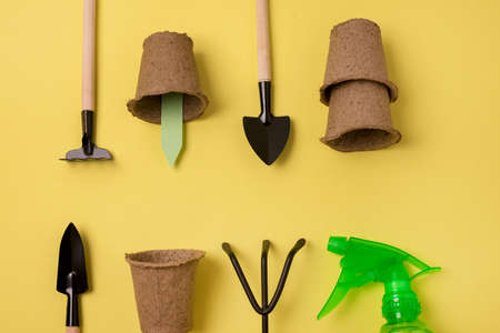 Gardening Tools on Spring Yellow Background Tool Concept Pots Shovel Rake Sprayer Flat Layの写真素材