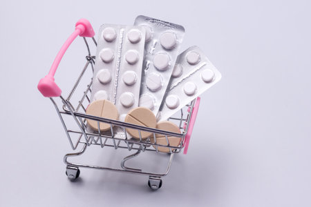 Shopping trolley with Pills and Medicine Above Blue Background Copy Spaceの写真素材
