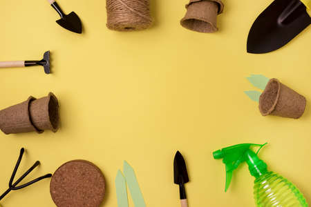 Gardening Tools on Spring Yellow Background Tool Concept Pots Shovel Rake Sprayer Flat Layの写真素材
