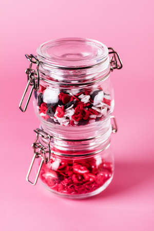Colorful Sprinkles Jars with Sprinkles on Pink Background Confectionery Decor Verticalの写真素材