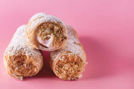 Three Tasty Homemade Pastry Tubes with Cream on Yellow Background Selective Focus Sweet Tube with Whipped Cream Close Upの写真素材