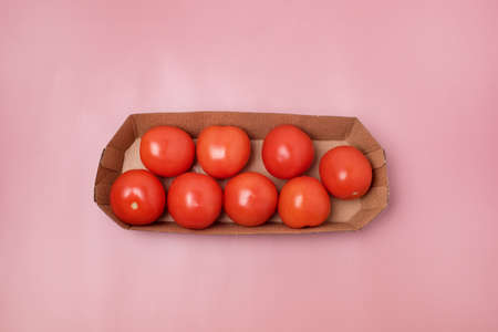 Small Red Tomatoes on Paper Basket on Pink Background Vegetable Horizontalの写真素材