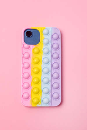 Mobile Phone with Colorful Pop it Case Pink Background Verticalの写真素材