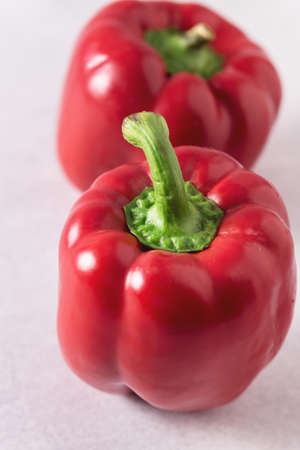 Two Raw Red Pepper on Light Gray Background Close Up Verticalの写真素材
