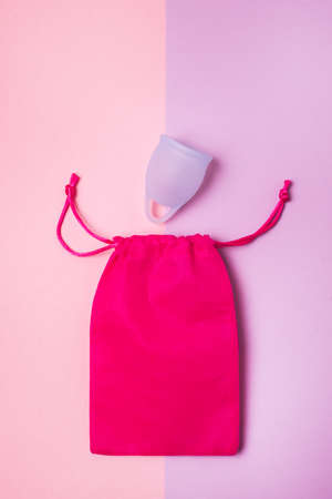 Two Menstrual Cups with Pink Bag on Pink and Purple Background Minimal Female Period Conceptの写真素材