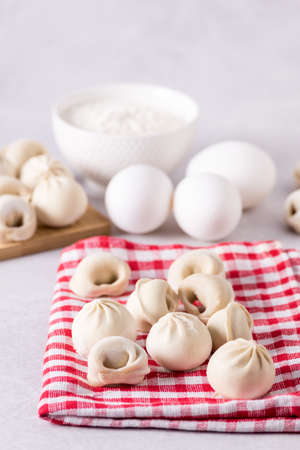 Homemade Semi-Finished Pelmeni Dumplings on the Napkin Ingredients for Cooking Pelmeni Gray Background Verticalの写真素材