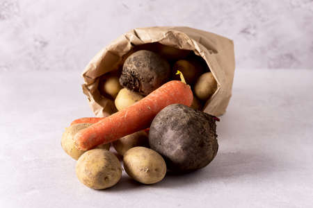 vegetables on a wooden table, potatoes, carrots, beet, onionsの写真素材