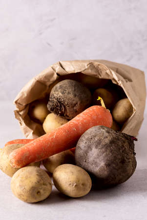 vegetables on a wooden table, potatoes, carrots, beet, onionsの写真素材