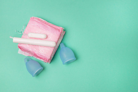 Pads Menstrual Cup Tampon on Green Background Concept of Critical Days Menstruation Horizontal Copy Spaceの写真素材