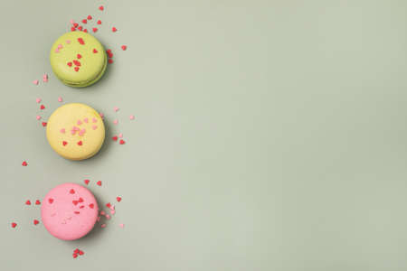Tasty French Macarons on Green Background Pink Yellow and Green Macarons Place for Text
