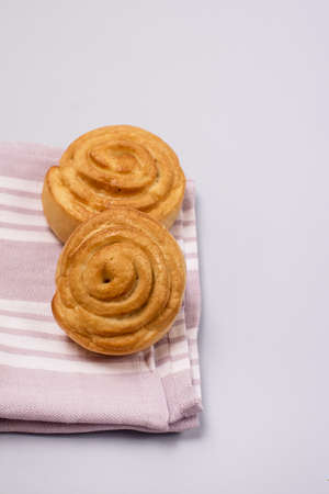 Fresh Sweet Homemade Cinnamon Rolls on pink Napkin Verticalの写真素材