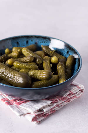 Small pickled cucumbers Traditional recipe served in a ceramic bowl gherkins gray backgroundの写真素材