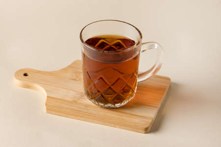 Glass Cup of Black tea on wooden tray Yellow backgroundの写真素材