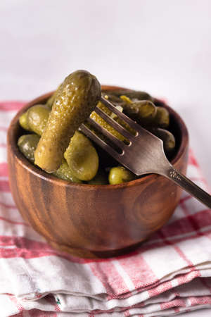 Small Pickles Marinated Pickled Cucumbers in wooden bowl on Napkin Gray Backgroundの写真素材