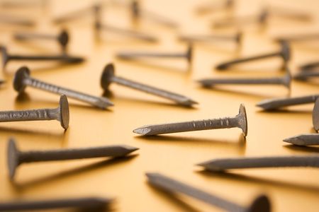 Metal nails on Gold Background - shallow focus.の写真素材