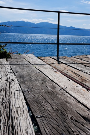 Wooden bridge on the sea coast with sunset and clouds の写真素材