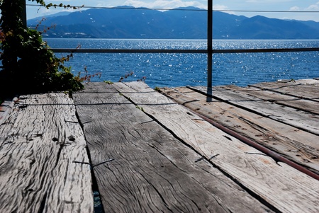 Wooden bridge on the sea coast with sunset and clouds の写真素材