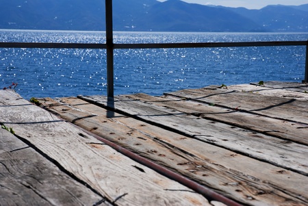 Wooden bridge on the sea coast with sunset and clouds の写真素材