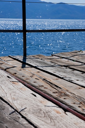 Wooden bridge on the sea coast with sunset and clouds の写真素材