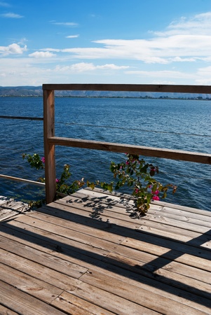 Wooden bridge on the sea coast with sunset and clouds の写真素材