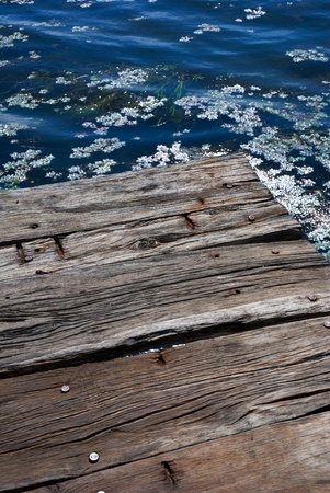 Wooden bridge on the sea coast with sunset and clouds の写真素材