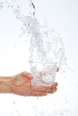 Water bottle in hand, in a spray of water dropletsの写真素材