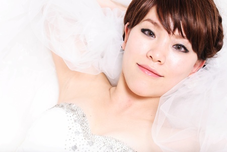 bride sitting in wedding dress, studio shotの写真素材