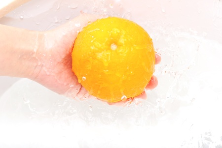 Fresh sweet orange under drops of waterの写真素材