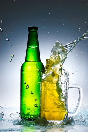 Beer bottle with water splashの写真素材