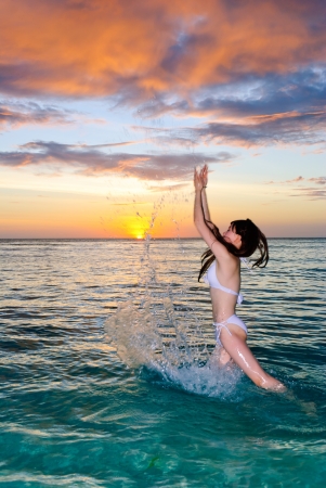 Sexy brunette woman in water at sunset .Erotic art photo.の写真素材